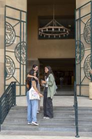 Students standing on SSE building stairs smiling 