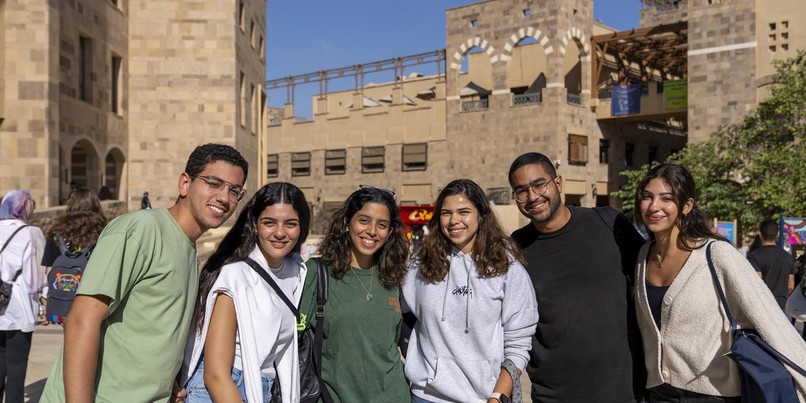 students on campus smiling in a group photo