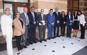 A group of women and men from AUC and Attijariwafa bank Egypt pose for a photo in front of a classroom