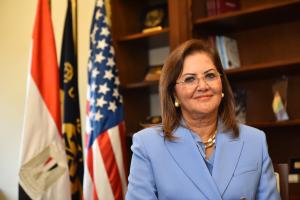Hala Elsaid standing in front of an Egyptian and American flag