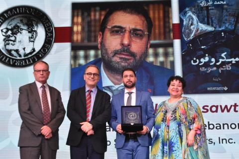 Group photo with the Naguib Mahfouz Medal winner holoding a trophy and standing with AUC President Ahmad Dalal, AUC Press Executive Director Thomas Willshire and Jury Chair Sarah Enany
