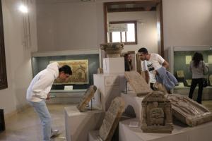 Students bending down and standing in front of Coptic monuments to examine them