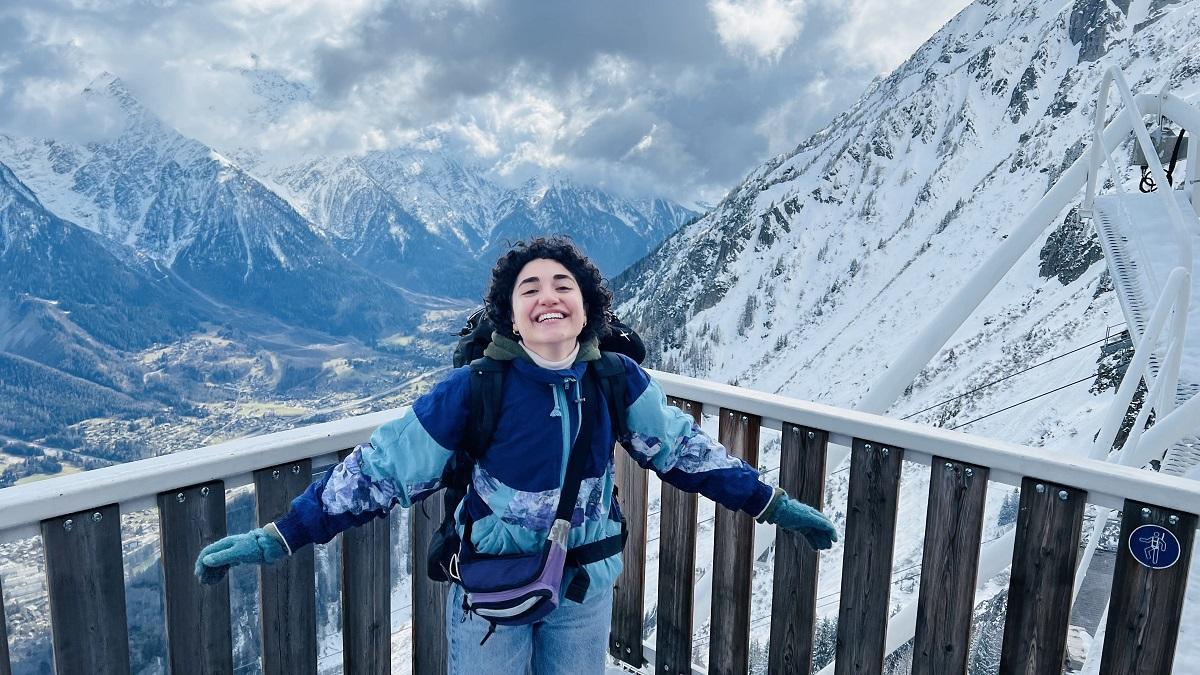 A female is leaning on a fence in the middle of snow