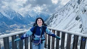 A female is leaning on a fence in the middle of snow
