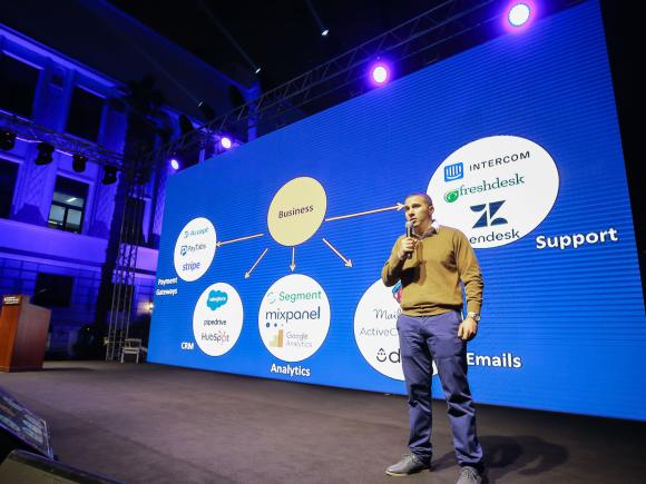 a man standing on a stage speaking in a microphone