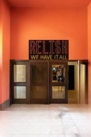 A wooden door with a sign written on it Relish 